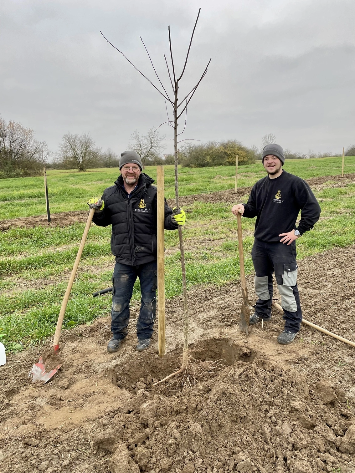 Mein Vater und Leon Pflanzen einen unserer Bäume ein